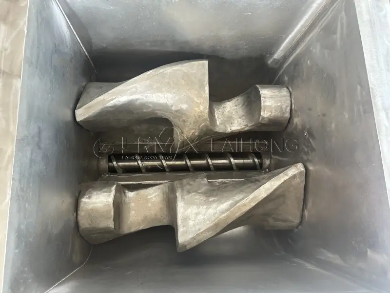 Interior view of 300L sigma mixer showing heavy-duty Z-blades and bottom discharge screw. Stainless steel mixing chamber of screw extruding kneader.